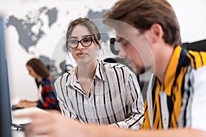 Business couple working together on project using tablet and desktop computer at modern open plan startup office