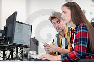 Business couple working together on project using tablet and desktop computer at modern open plan startup office