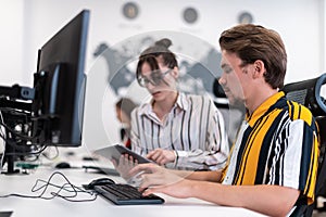 Business couple working together on project using tablet and desktop computer at modern open plan startup office