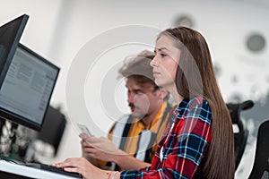 Business couple working together on project using tablet and desktop computer at modern open plan startup office