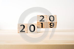 Business and design concept - surreal abstract geometric floating wooden cube with word 2020 and 2019 concept on wood floor and wh