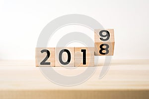 Surreal abstract geometric floating wooden cube with word 2019 and 2018 concept on wood floor and white background