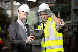 Business director and Mechanic engineer checking and discussing at factory shop floor