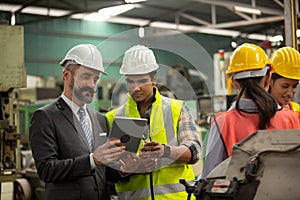 Business director and Mechanic engineer checking and discussing at factory shop floor