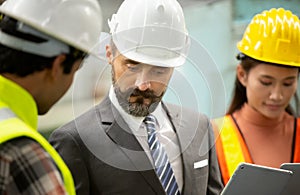 Business director and Mechanic engineer checking and discussing at factory shop floor