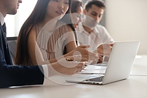 Business discussion, asian employee talking to colleague pointing at laptop