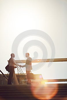 Business doesnt always happen in the office. Low angle shot of two businessmen shaking hands on top of a staircase