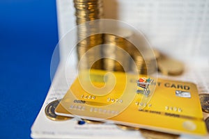 Business, E-Commerce and Money Concept. Closeup of miniature shopping cart or trolley on mockup fake yellow credit card with pile