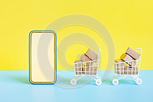 Business ecommerce or online shopping concepts with smartphone and product box order in trolley