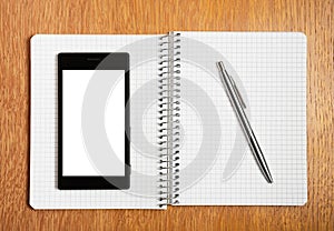 Business and education concept - smartphone and notepad