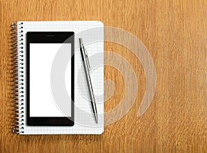 Business and education concept - smartphone and notepad