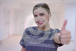 Business, education and sucess concept, Young female business woman standing and looking at camera with finger up photo