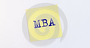 Business educatuion concept. yellow paper sticker with text MBA acronym on yellow paper note on white table or wall, master of