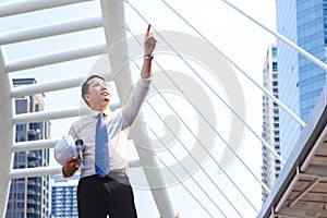 Business engineer man looking plan on site, Architect pointing at construction site