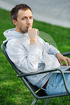 Business entrepreneur work on laptop outdoors sitting on chair in backyard or park emailing remotely