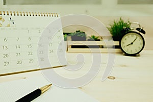 Business equipment include pen, graph paper, calendar placed on