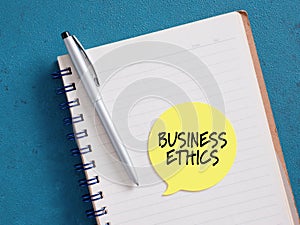 Business ethics reminder note on notebook with pen