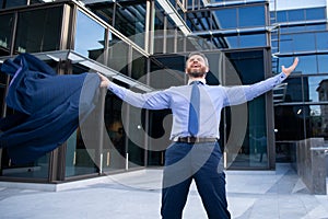 Business excitement. Business man keeping arms raised and expressing positivity outdoors. Businessman jumping for joy