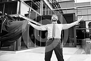 Business excitement. Business man keeping arms raised and expressing positivity outdoors. Businessman jumping for joy