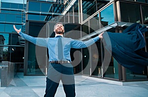 Business excitement. Business man keeping arms raised and expressing positivity outdoors. Businessman jumping for joy