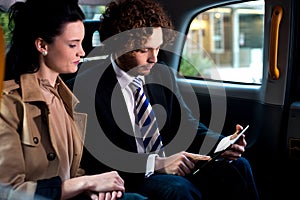 Business execitives in taxi cab