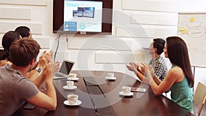 Business executive applauding during a video conference