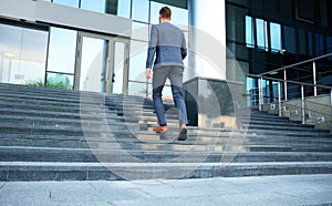 Business executive with briefcase going up the stairs.