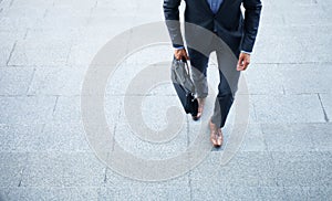 Business executive with briefcase going up the stairs.