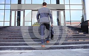 Business executive with briefcase going up the stairs.