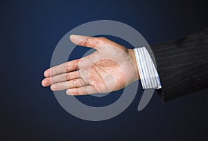 Business executive extending arm to shake hands