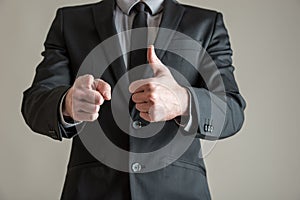 Business executive making a thumbs up gesture with one hand and