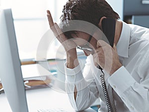 Business executive receiving bad news on the phone