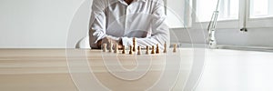 Business executive sitting at his desk with chess pieces positioned in front of him