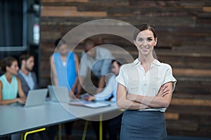 Business executive standing with arms crossed in office