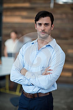 Business executive standing with arms crossed in office