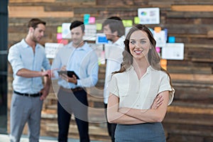 Business executive standing with arms crossed in office