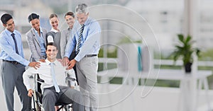 Business executives consoling their colleague sitting on wheelchair