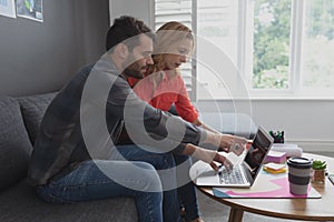 Business executives discussing over laptop