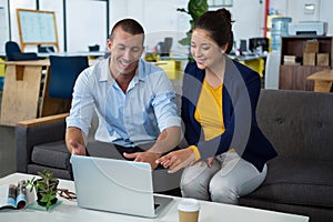 Business executives discussing over laptop