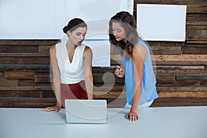 Business executives discussing over laptop