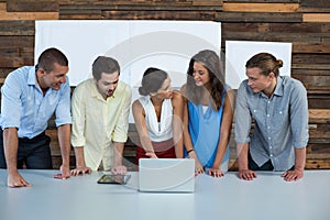 Business executives discussing over laptop