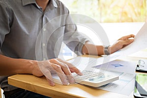 Business executives hands using calculator to calculate tax Invoice and set new project business strategy plan with data document