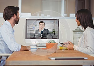 Business executives having video call with colleague on desktop computer