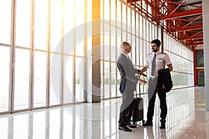 Business executives man and helicopter Commercial pilot in uniform  hand shake and talking together