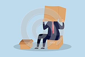 Business failure and fail entrepreneur concept, depressed businessman sitting covered his head with box, shameful cannot face