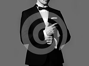 Business fashion look. Man fixing cufflinks. Gentleman in black suit. Elegant and stylish clothes.