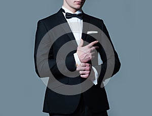 Business fashion look. Man fixing cufflinks. Gentleman in black suit. Elegant and stylish clothes.