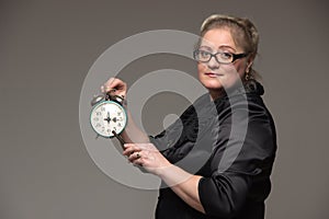 Business fat woman with a clock indicates that the time has come