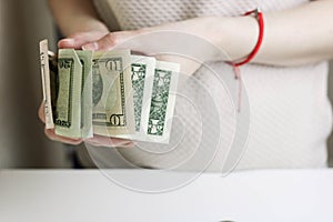Business, finance, banking and people concept - close up of woman hands counting us dollar money