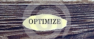 Business and finance concept. Top view of piece of paper written word OPTIMIZE on the wooden background